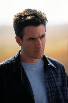 a man in a plaid shirt looking at the camera