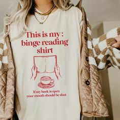 a woman wearing a t - shirt that says, this is my binge reading shirt