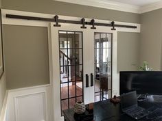 a computer desk with a laptop on top of it next to a sliding glass door