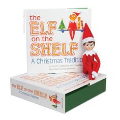 the elf on the shelf is next to a christmas card box with an elf in it