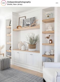 a living room filled with lots of white furniture and shelves full of plants on top of them