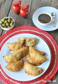 several pastries on a plate next to bowls of olives