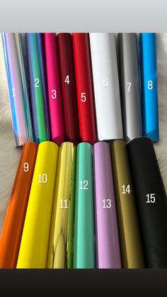 several different colors of plastic wrappers on top of a white surface with numbers in the middle