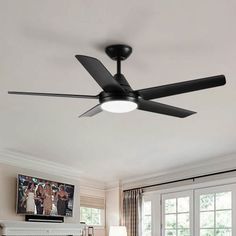 a ceiling fan in a living room with a flat screen tv mounted on the wall