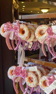 donuts with pink bows and sprinkles are on display in a store