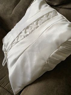 a white pillow sitting on top of a brown couch