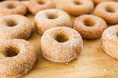 several sugared donuts on a wooden cutting board