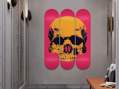 a skateboard with a skull on it is hanging in a hallway next to a desk