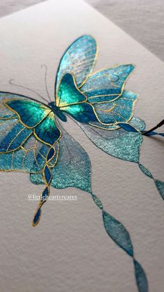 a blue and gold butterfly on white paper