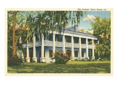 an old postcard shows the front of a white house with trees and bushes around it