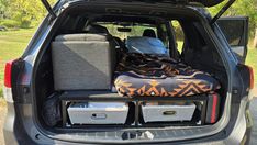 the back end of a vehicle with its trunk open and luggage in it's cargo compartment