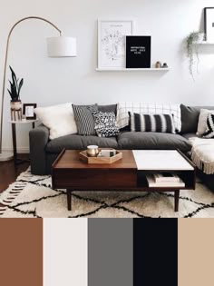 a black and white living room with lots of pillows on the couch, coffee table