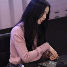 a woman sitting at a desk with her hands on her chest