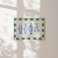 three blue fish on a green and white checkerboard pattern framed in wooden frame