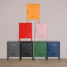 four different colored lockers sitting next to each other on top of a cement floor