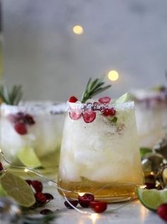 two glasses filled with alcohol and garnished with pomegranates