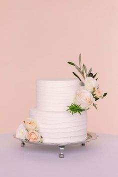 a three tiered white cake with flowers on top