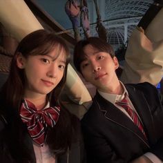 two young people wearing suits and ties posing for a photo in front of an aquarium