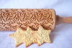 two cookies in the shape of stars are next to a rolling pin