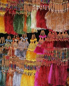 many necklaces and bracelets are hanging on the wall in front of each other