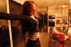 a woman standing in a kitchen next to a counter