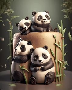 three panda bears sitting on top of a cake