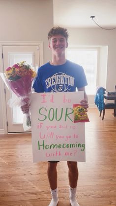 a young man holding flowers and a sign