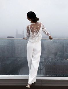 a woman standing on top of a building looking out at the cityscape with buildings in the background