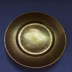 an empty gold plate on a blue surface