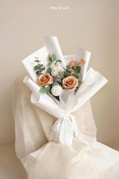 a bouquet of flowers wrapped in white paper