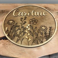 a wooden plaque with flowers and the word careline carved into it's sides