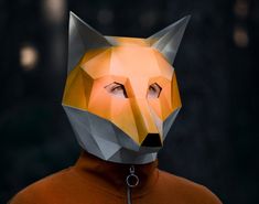 a person wearing a fox mask with their eyes closed and one eye partially open, in front of a dark background