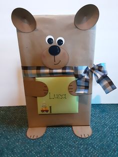 a paper bag shaped like a bear holding a sign with the word luce written on it