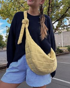 a woman with a banana shaped bag on her shoulder