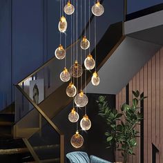 a modern chandelier hanging from the ceiling in a living room with blue couches