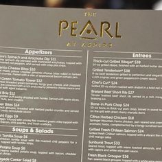 a menu for the pearl at aspire is shown in front of a blurry background