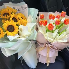 two bouquets of sunflowers and tulips in the back seat of a car