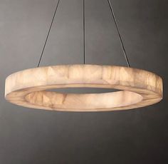 a circular wooden light fixture hanging from a chandelier with two lights on each side