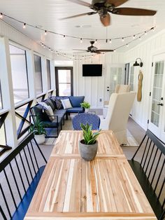 a wooden table sitting on top of a hard wood floored porch next to a blue couch