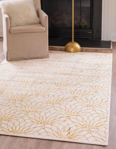 a living room area with a chair, fireplace and large rug on the hardwood floor