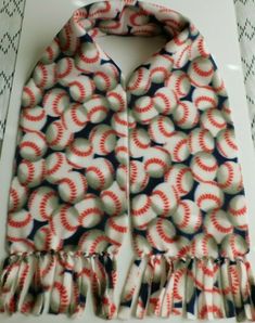 a scarf with red and white baseballs on it sitting on top of a table