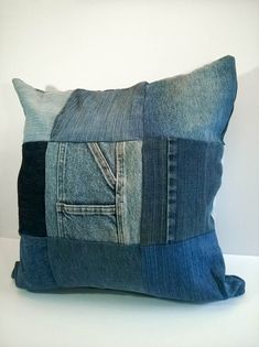 a pillow made out of blue jeans with a patchwork design on the front and back