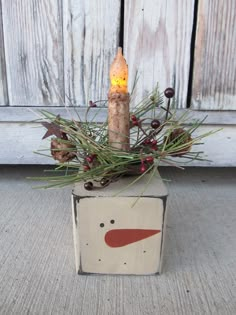 a wooden box with a lit candle in it