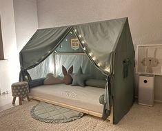 a child's tent bed with bunny ears on the side and lights in the roof