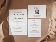 the wedding stationery is laid out on a bed sheet