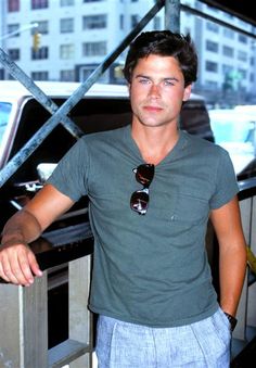 a young man standing in front of a car