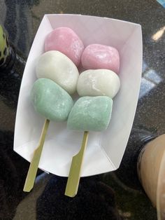 marshmallows are on sticks in a paper bowl