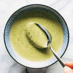 a spoon in a bowl filled with broccoli soup