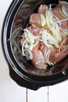 meat and onions are being cooked in the slow cooker