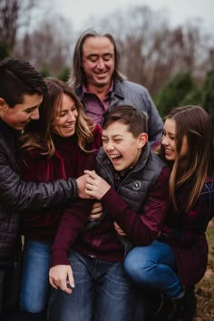 a group of people standing around each other in front of a christmas tree lot smiling at the camera